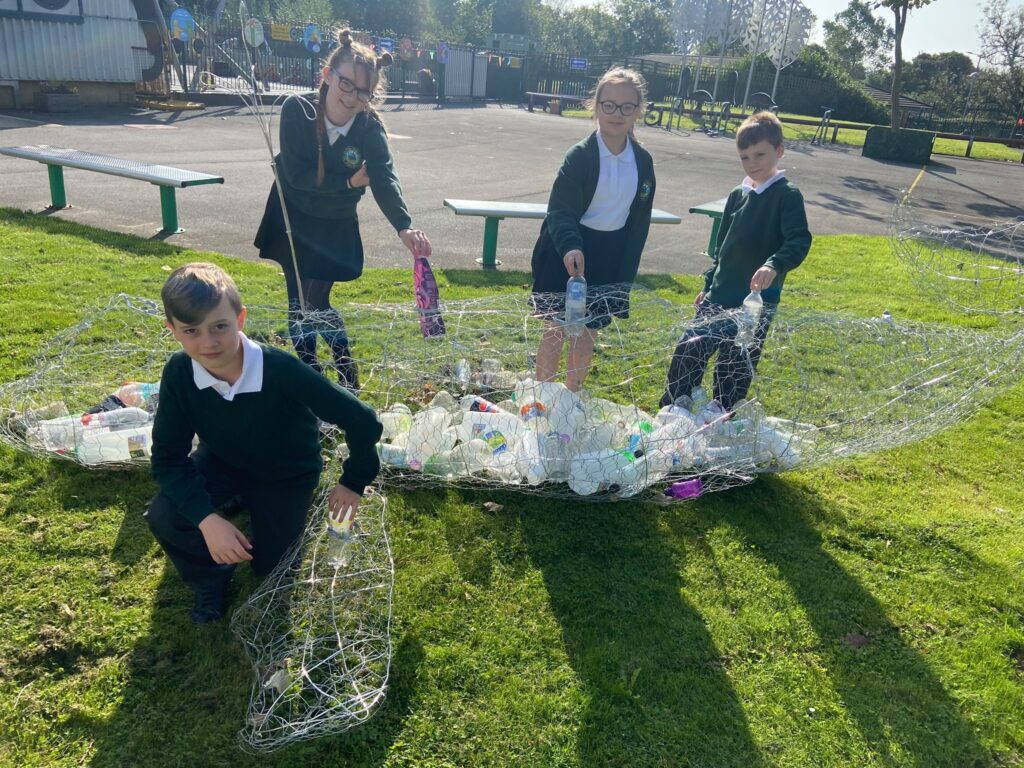 Four children collecting plastic waste