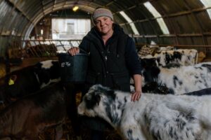 Community Champion Becky Land standing with cow